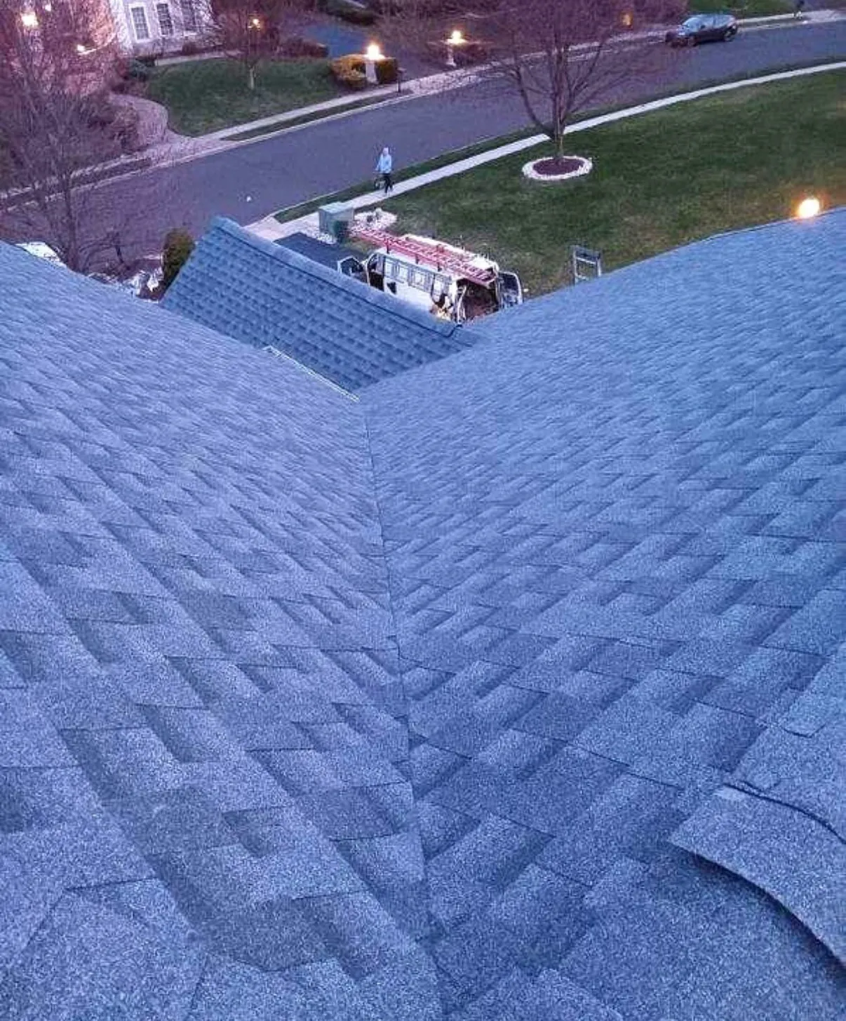 Valley detail on a completed blue-gray architectural shingle roof at dusk