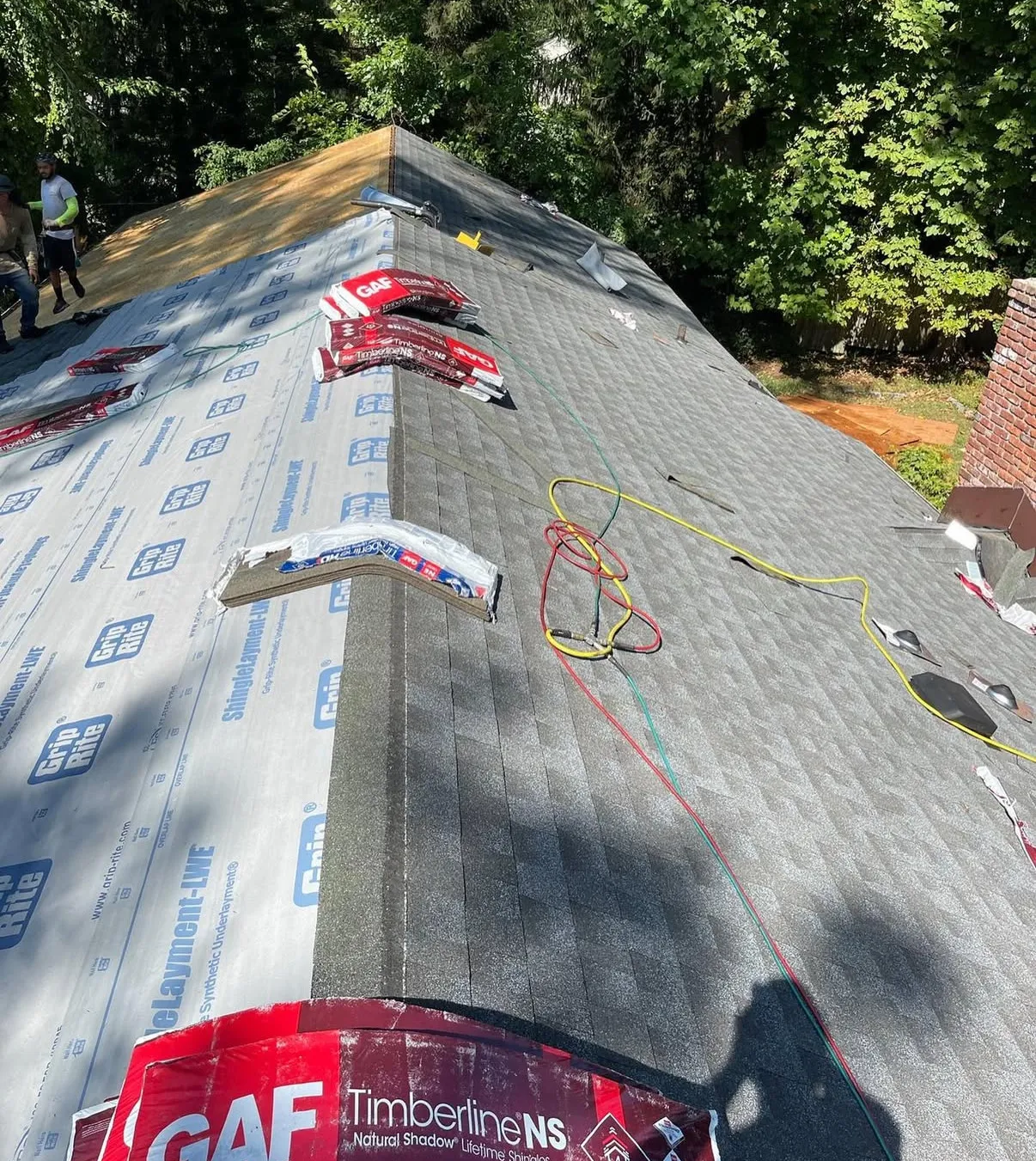 Capital T crew mid-installation: GAF Timberline shingles going down over fresh synthetic underlayment