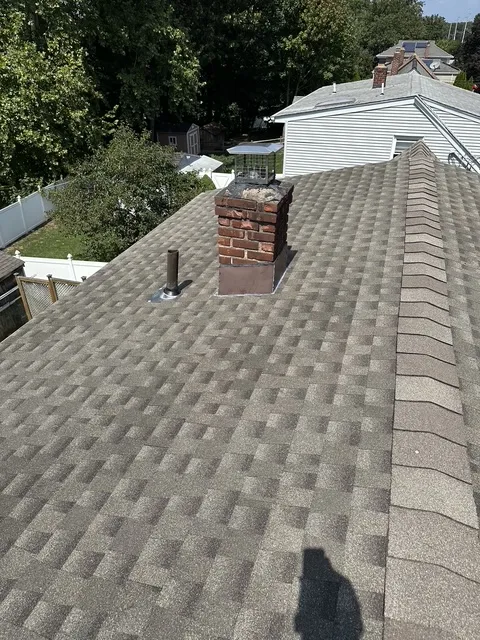 Completed roof replacement in Pompton Plains NJ — new architectural shingles, brick chimney with new flashing and cap