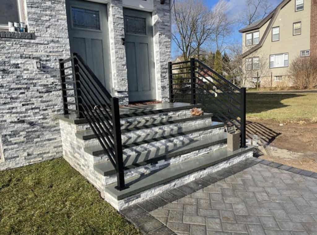 New front steps installed in front of a home with brick siding.